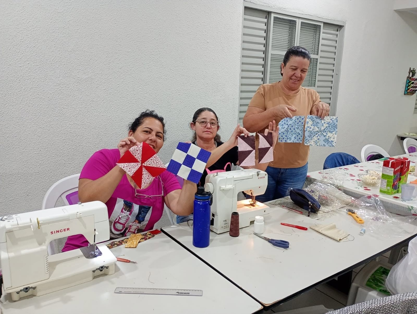 Alunas do curso de costura criativa mostrando os retalhos montados